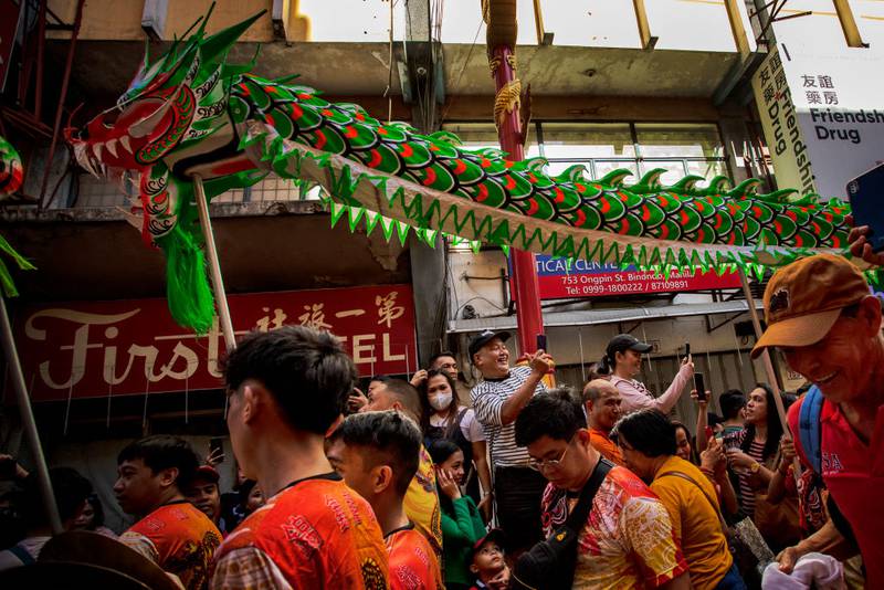 MANILA, PHILIPPINES - FEBRUARY 10: Filipinos watch dragon dancers perform during Lunar New Year celebrations at Binondo district, considered the world's oldest Chinatown, on February 10, 2024 in Manila, Philippines. Lunar New Year, also known as Chinese New Year, is celebrated around the world, and the year of the Wood Dragon in 2024 is associated with growth, progress, and abundance, as wood represents vitality and creativity, while the dragon symbolizes success, intelligence, and honor.  (Photo by Ezra Acayan/Getty Images)