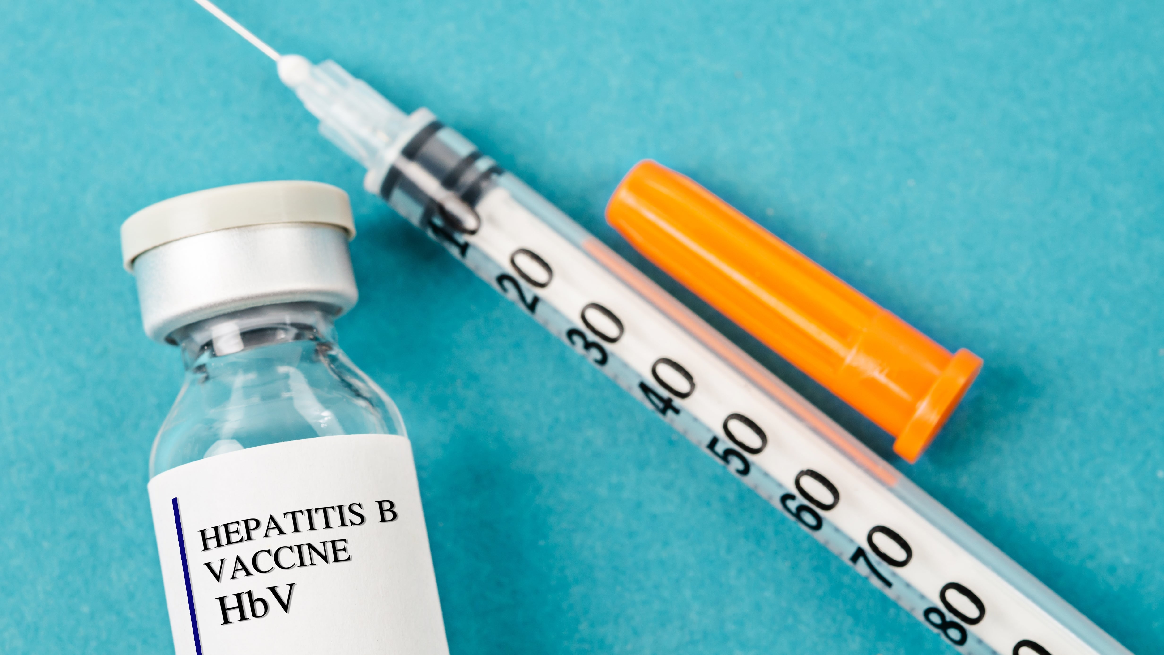 Hepatitis B HBV vaccine vial with syringe in laboratory background.