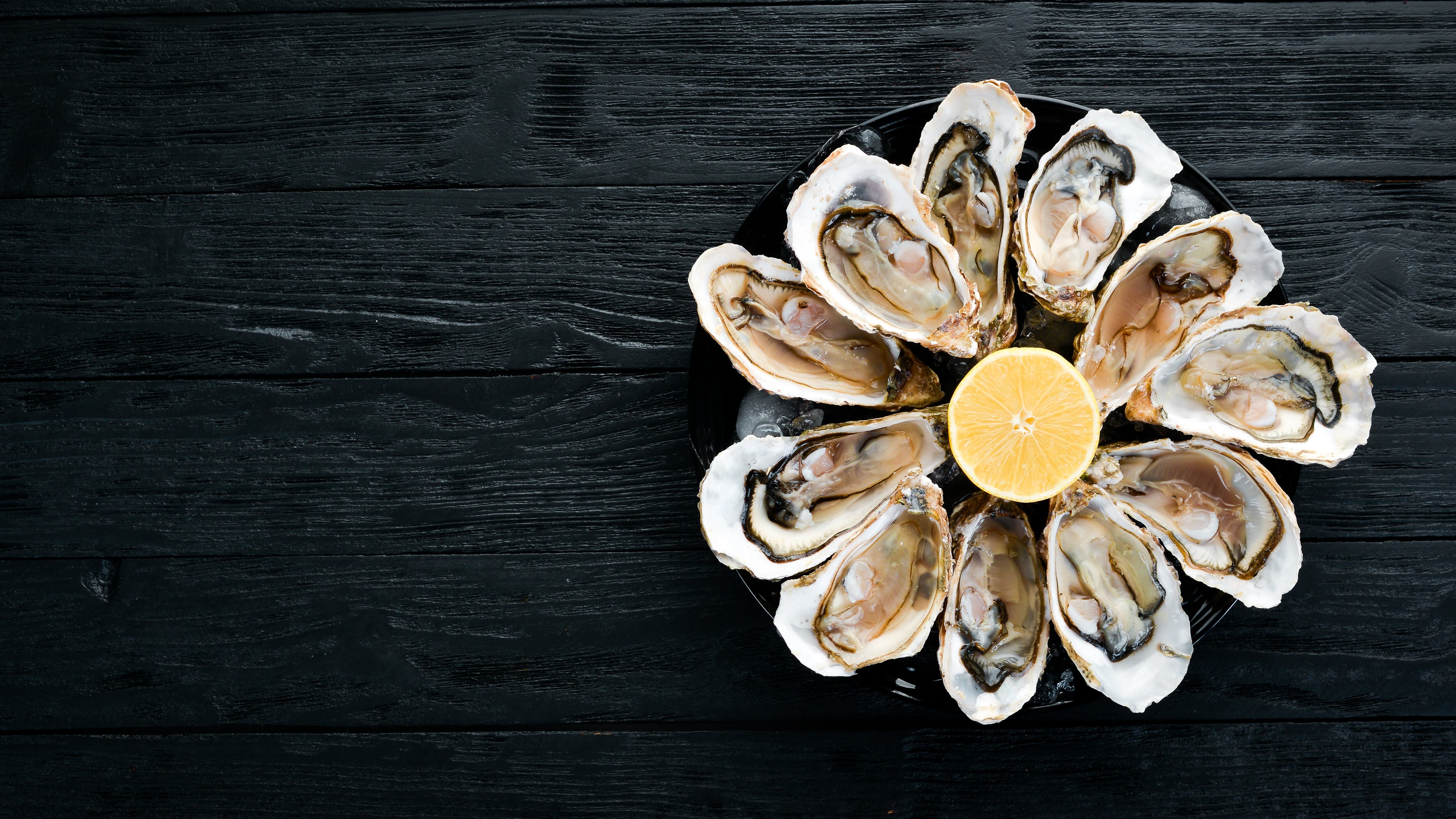 Fresh oysters in a plate of ice and lemon. Seafood.