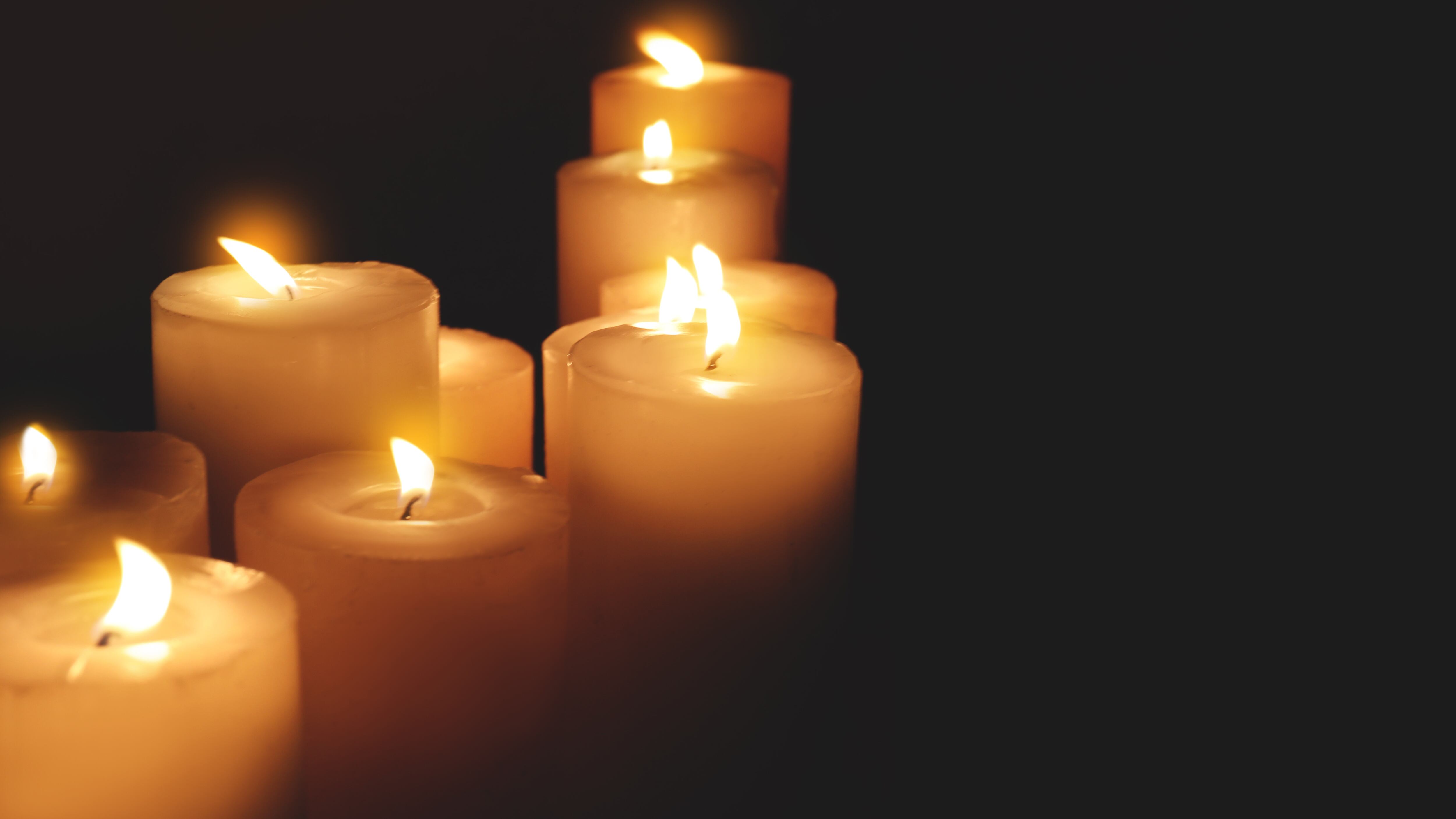 Many burning candles on dark background